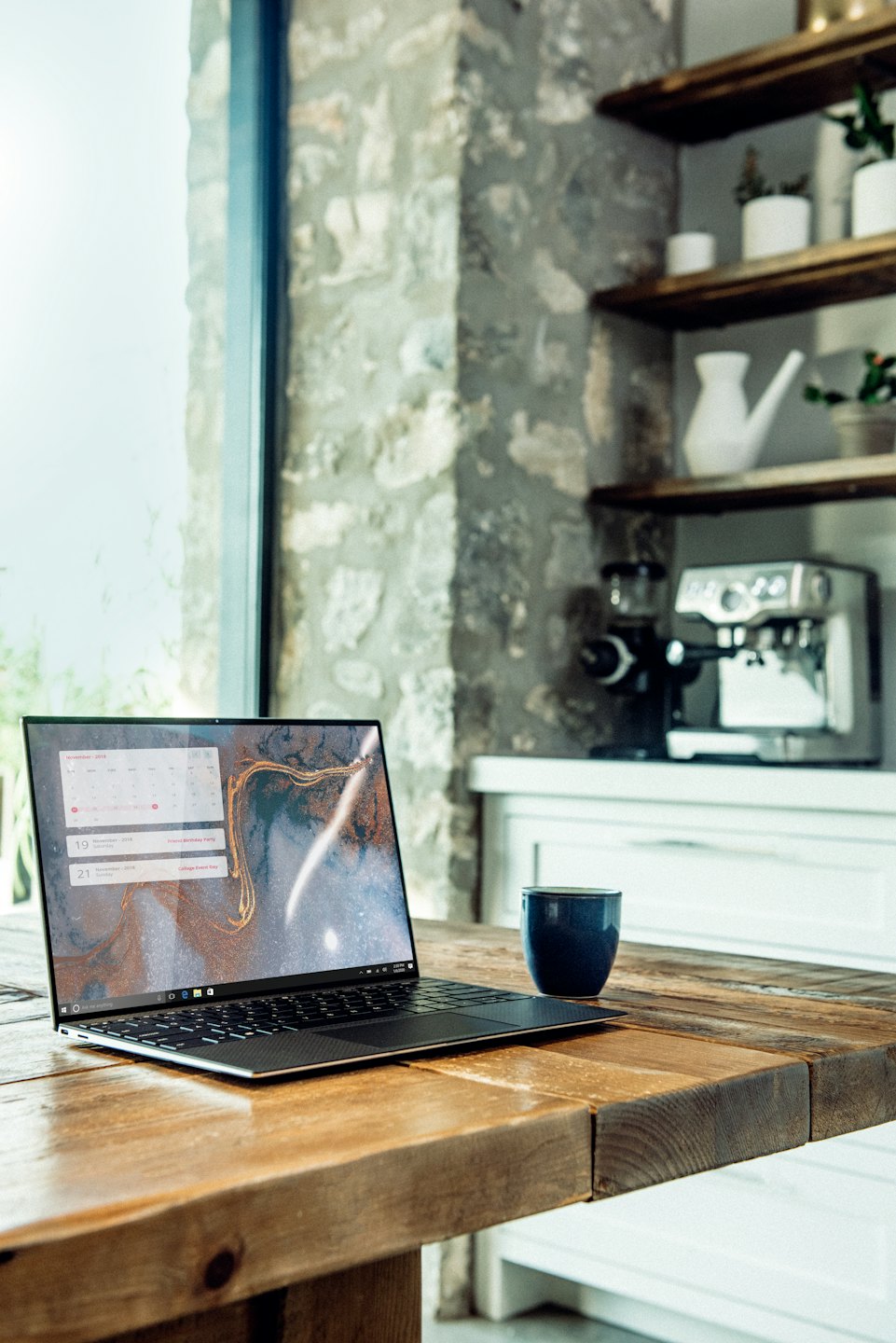 Laptop su un tavolo rustico con calendario di novembre.